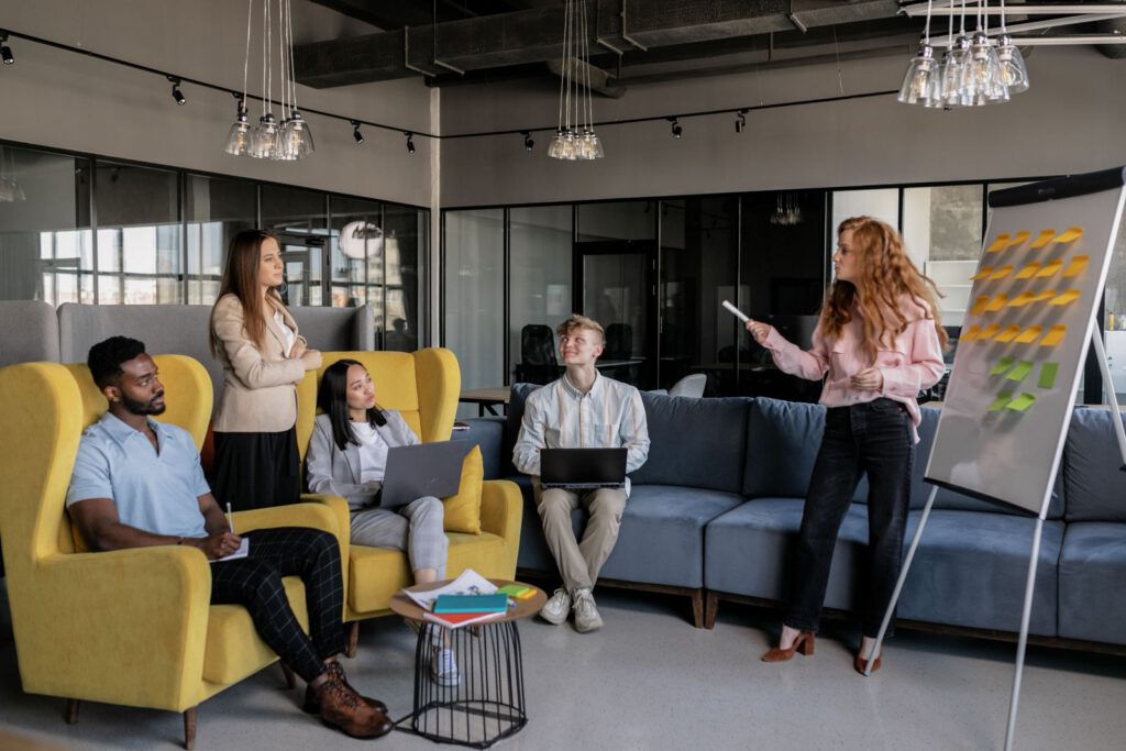 Team in an office lounge during a presentation at a sticky-note board