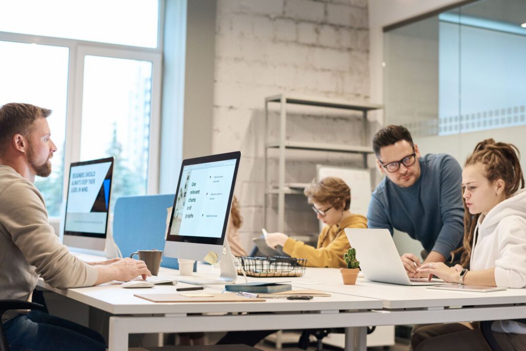 Team members working together at desktop computers in a bright office