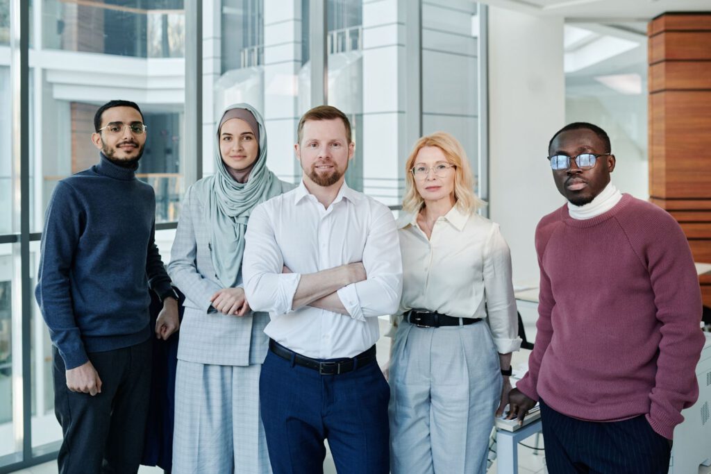 Five team members standing together in a bright office