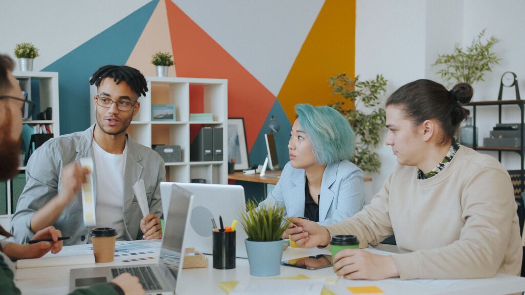 Colleagues discussing work at a shared desk