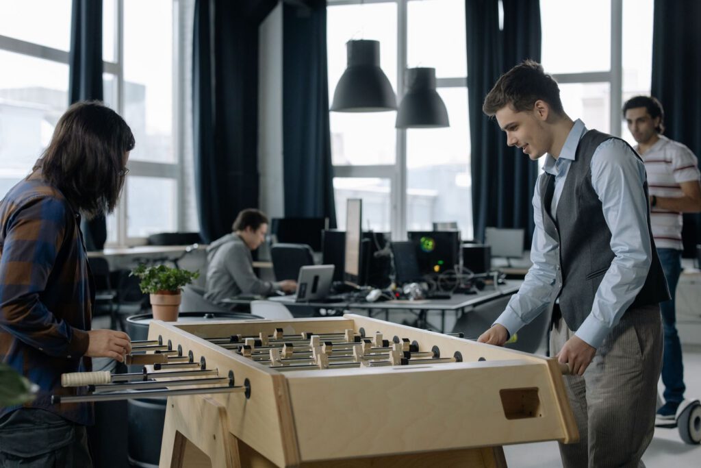 Colleagues playing table football in an office