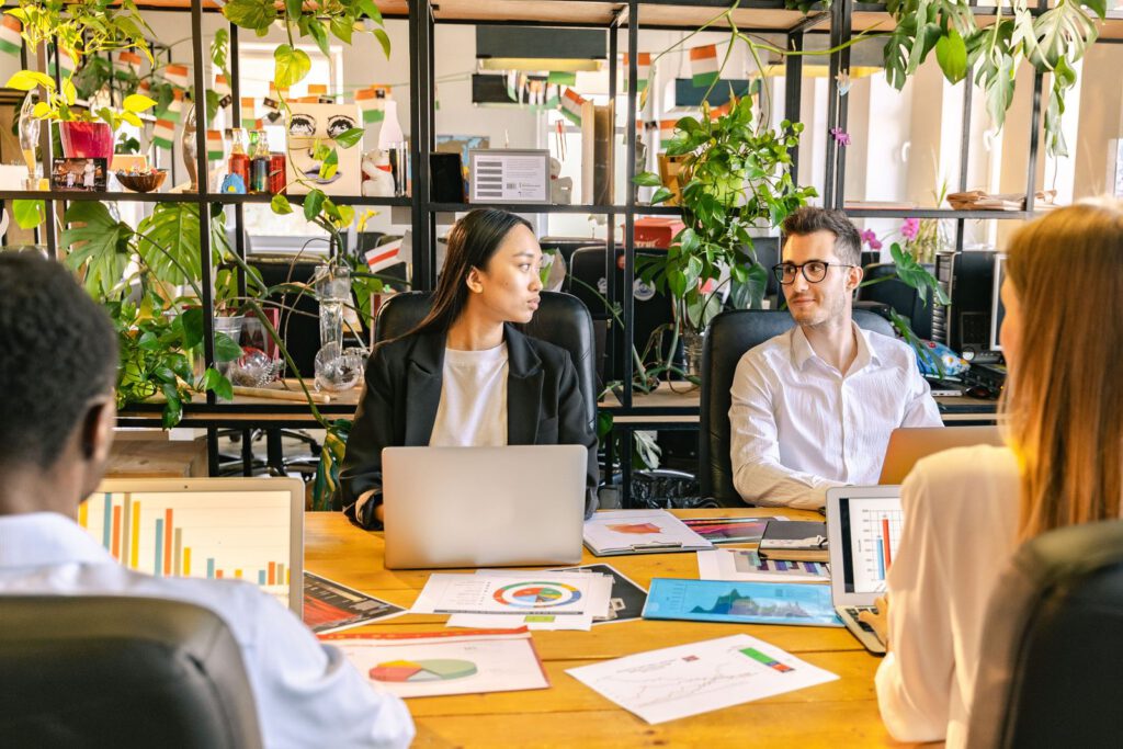 Colleagues talking across a table covered with charts
